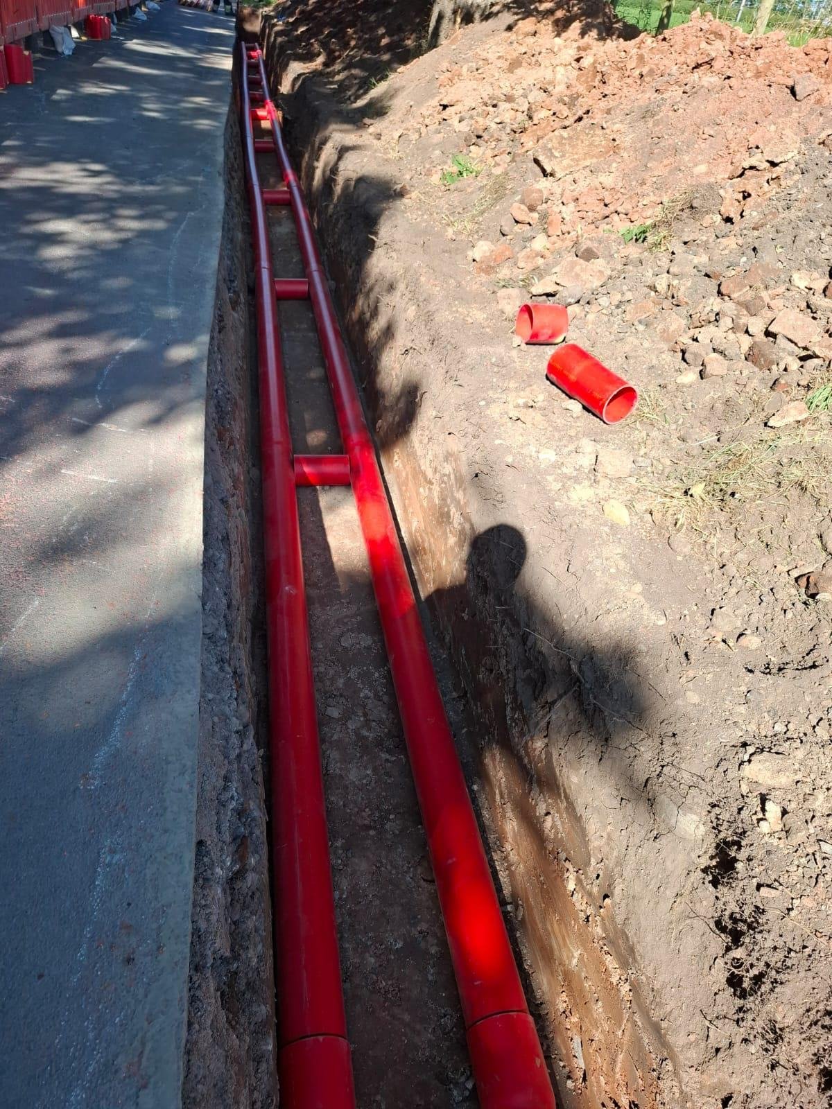 Ducts in a trench beside a footway, ready for surround and backfill